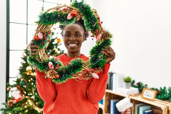 Mujer Afroamericana Sonriendo Confiada Sosteniendo Decoración Coronas Navidad Casa — Foto de Stock