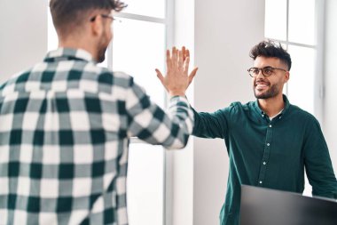 Young couple business workers high five with hands raised up at office