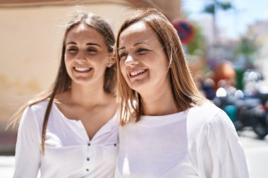 Sokakta yan yana duran iki kadın anne ve kız.