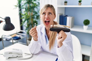 Güzel dişçi kadın dişlerini beyazlatıyor kızgın ve deli gibi bağırıyor hayal kırıklığına uğramış ve öfkeli, öfkeyle bağırıyor.. 