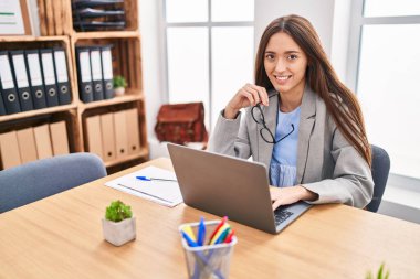 Young beautiful hispanic woman business worker using laptop working at office