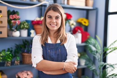 Young woman florist smiling confident standing with arms crossed gesture at florist