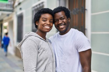 African american man and woman couple smiling confident hugging each other at street
