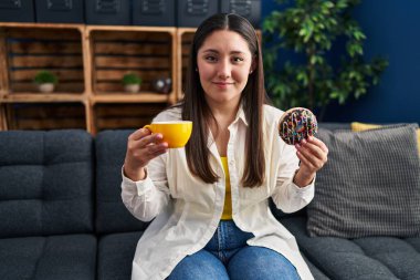 Genç İspanyol kadın evde kahvaltı ederken kendine güler yüzlü.