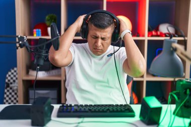 İspanyol asıllı genç bir adam video oyunları oynuyor. Baş ağrısı, çaresiz ve stresli. Çünkü acı ve migren. Eller başının üstünde.. 