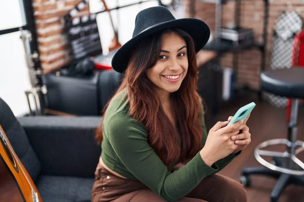 Young Hispanic Woman Musician Using Smartphone Sitting Sofa Music Studio — 图库照片