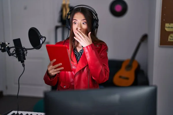 Młoda Brunetka Śpiewa Piosenkę Używając Mikrofonu Zakrywającego Usta Ręką Zszokowana — Zdjęcie stockowe