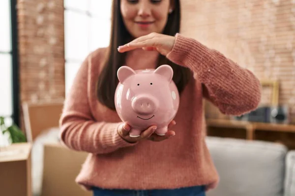 Young Hispanic Woman Smiling Confident Holding Piggy Bank New Home — Zdjęcie stockowe