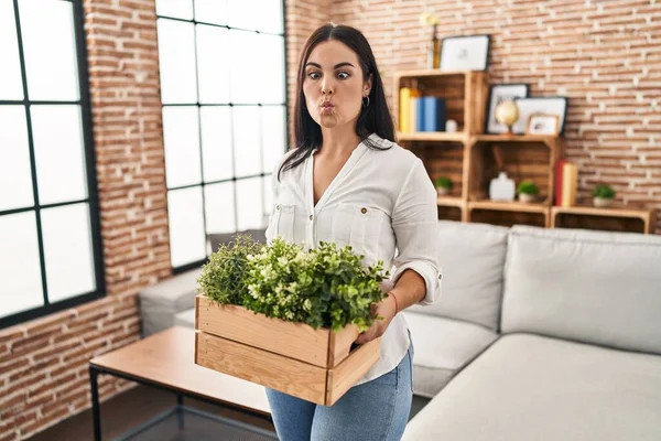 Young Hispanic Woman Holding Green Plants Living Room Making Fish — Stock Photo, Image