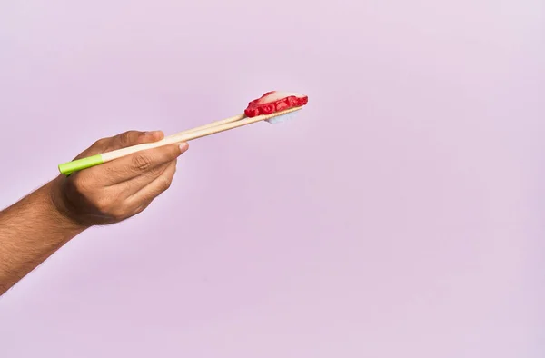 Mano Dell Uomo Possesso Polpo Nigiri Con Bacchette Sfondo Rosa — Foto Stock