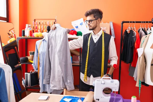 Atölyede terzi tişörtü tutuyor.