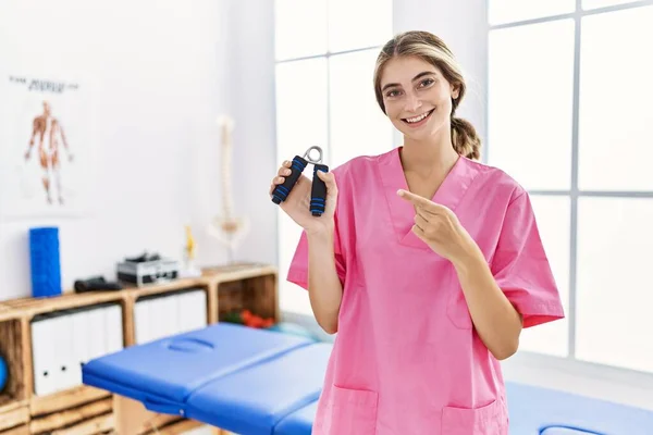 Joven Mujer Rubia Trabajando Clínica Recuperación Del Dolor Sosteniendo Fortalecedor —  Fotos de Stock