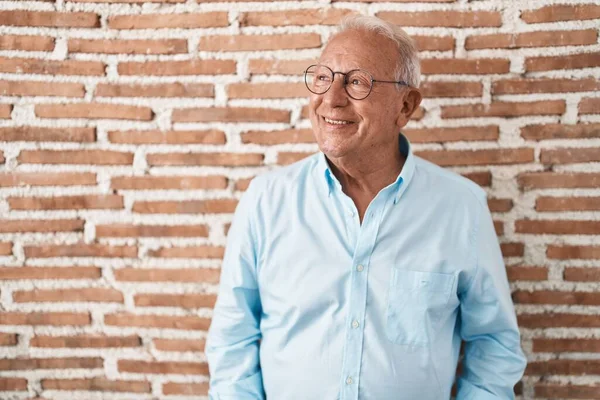 Starší Muž Šedivými Vlasy Stojící Nad Cihlovou Zdí Usmívající Stranou — Stock fotografie