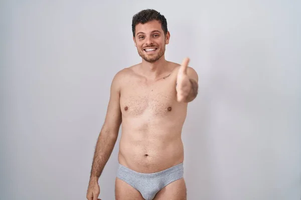 Ung Latinamerikansk Man Står Tröjlös Klädd Underkläder Leende Vänlig Erbjuder — Stockfoto