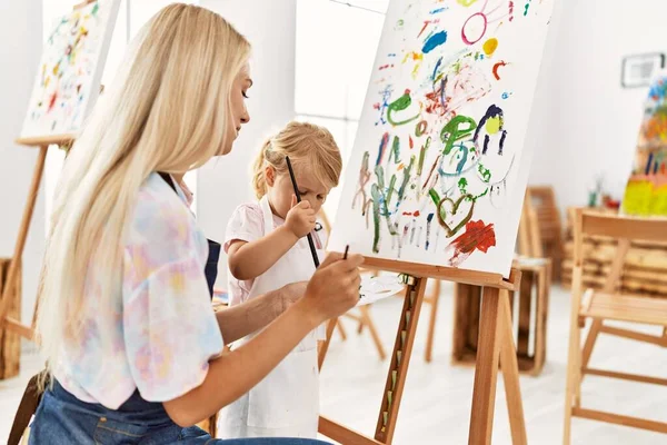 Mother and daughter concentrate drawing at art studio