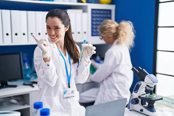 Молодая Латиноамериканка Работающая Лаборатории Учёных Улыбающаяся Счастливая Указывая Рукой Пальцем — стоковое фото