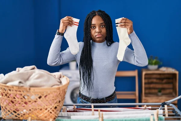 Mujer Afroamericana Sosteniendo Calcetines Relajados Con Expresión Seria Cara Simple —  Fotos de Stock