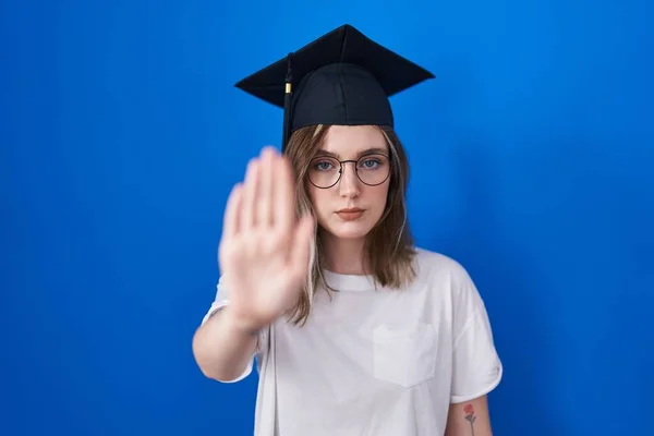 金发白种人女人戴着毕业帽 手掌心停止歌唱 用消极而严肃的手势警告人 — 图库照片