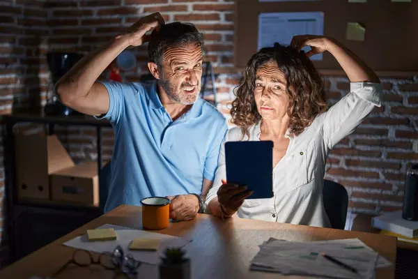 Coppia Ispanica Mezza Età Utilizzando Touchpad Seduto Sul Tavolo Notte — Foto Stock