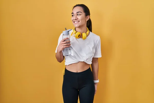 Ung Sydasiatisk Kvinna Bär Sportkläder Dricksvatten Tittar Bort Till Sidan — Stockfoto