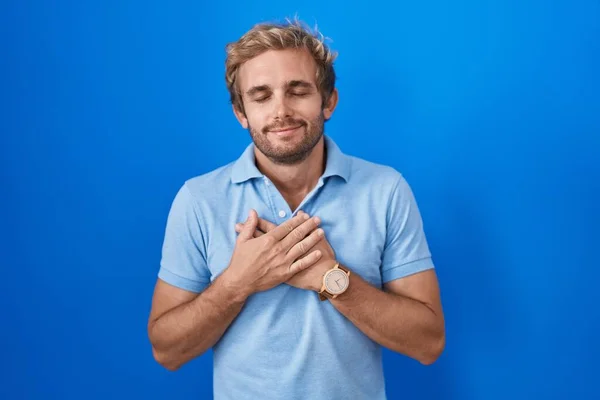 Caucasian Man Standing Blue Background Smiling Hands Chest Closed Eyes — 图库照片