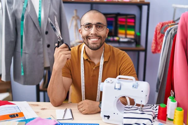 年轻的拉丁男人裁缝师微笑着 自信地拿着剪刀在工作室里 — 图库照片