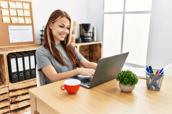 年轻的黑发女人带着笔记本电脑在办公室里工作 脸上带着快乐而沉着的笑容 幸运的人 — 图库照片