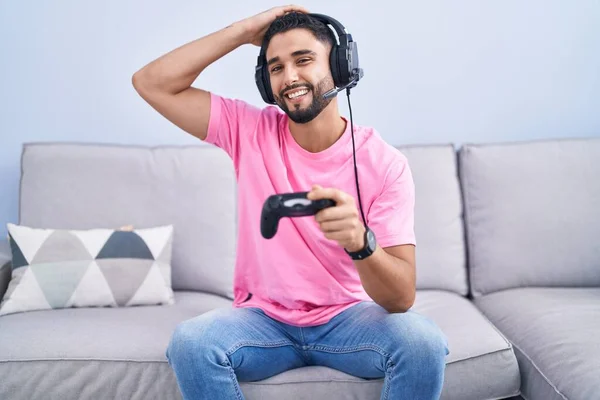 Jovem Hispânico Jogando Vídeo Game Segurando Controlador Sentado Sofá Sorrindo — Fotografia de Stock