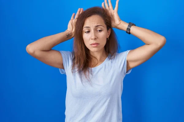 Brunette Woman Standing Blue Background Doing Bunny Ears Gesture Hands — Foto Stock