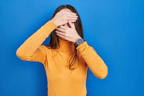 Jovem Morena Sobre Fundo Azul Cobrindo Olhos Boca Com Mãos — Fotografia de Stock