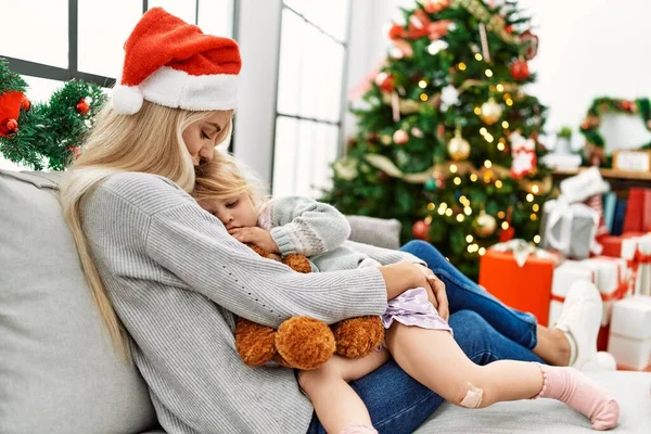 妈妈和女儿坐在家里的圣诞树旁互相拥抱 — 图库照片