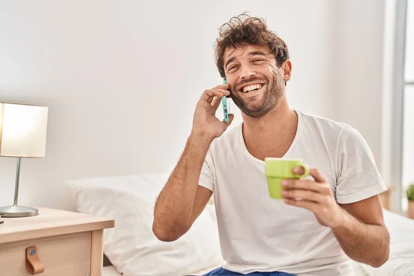 Junger Mann Telefoniert Mit Smartphone Und Trinkt Kaffee Schlafzimmer — Stockfoto