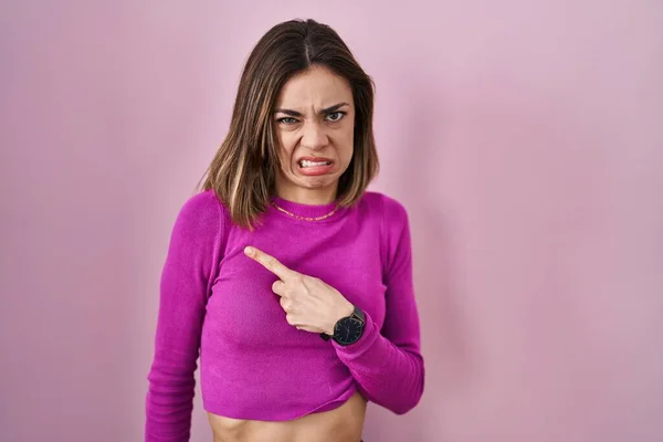 西班牙裔妇女站在粉红的背景上 用食指 关心和惊讶的表情将忧虑和紧张抛在一边 — 图库照片