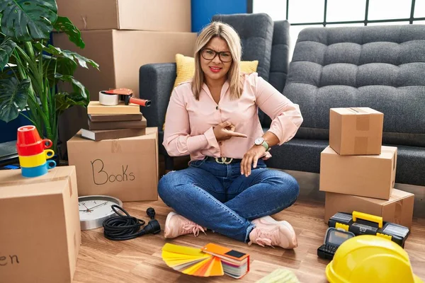 Young Hispanic Woman Moving New Home Sitting Floor Hurry Pointing —  Fotos de Stock