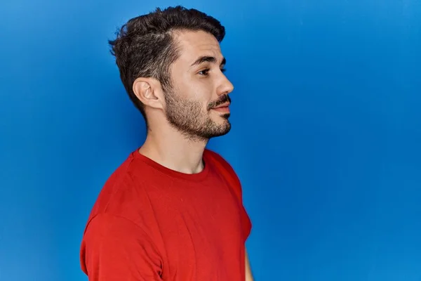 Young Hispanic Man Beard Wearing Red Shirt Blue Background Looking — Stok fotoğraf