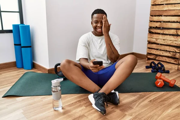Young African Man Sitting Training Mat Gym Using Smartphone Covering — Foto de Stock