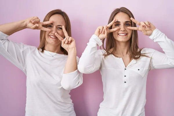 Middle Age Mother Young Daughter Standing Pink Background Doing Peace — ストック写真