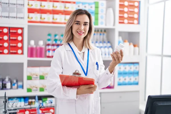 Joven Mujer Farmacéutico Sonriendo Confiado Sosteniendo Lista Verificación Pastillas Botella — Foto de Stock