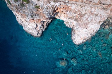 Rocky pit at Pasjaa beach. Tourists swimming to admire the beauty of nature.