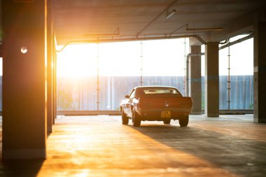 Wroclaw, Poland - May 11, 2022: Classic Mustang parked in a city garage on golden hour