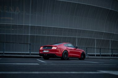 Wroclaw, Poland - August 15, 2022: Red Ford Mustang on industrial background