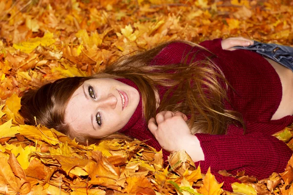 Hermosa mujer en hojas de otoño — Foto de Stock