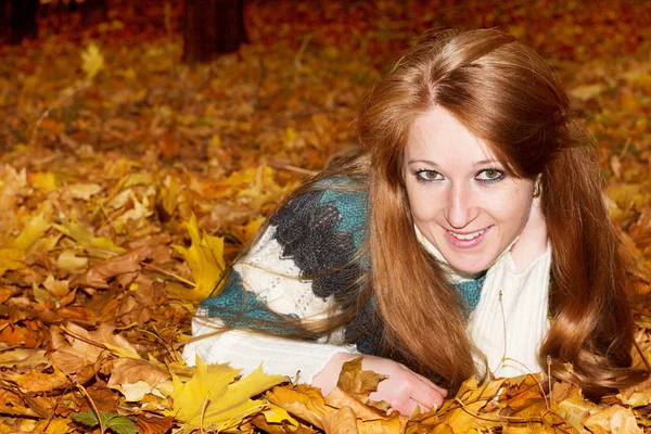 Hermosa mujer en hojas de otoño — Foto de Stock