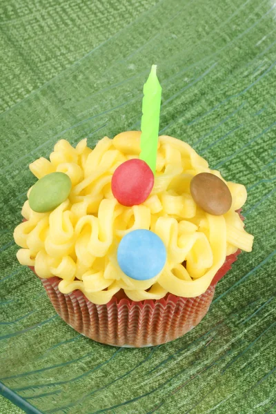 Cupcake with green candle — Stock Photo, Image