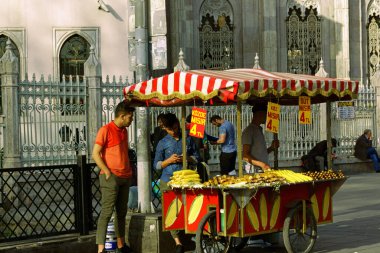 İstanbul, Türkiye - 26 Nisan 2019: İstanbul, Türkiye 'deki Pertevniyal Valide Sultan Camii önünde tipik mısır koçanı satıcısı. Etrafta birileri var..