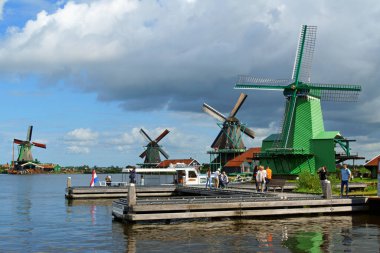 Zaandam, Hollanda - 13 Ağustos 2017: Amsterdam yakınlarındaki Zaandam kanalları ve yel değirmenleri boyunca yürüyen bazı turistler.