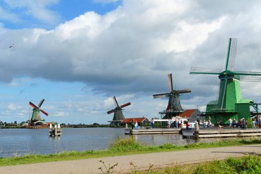 Zaandam, Hollanda - 13 Ağustos 2017: Amsterdam yakınlarındaki Zaandam kanalları ve yel değirmenleri boyunca yürüyen bazı turistler.