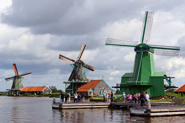 Zaandam, Hollanda - 13 Ağustos 2017: Amsterdam yakınlarındaki Zaandam kanalları ve yel değirmenleri boyunca yürüyen bazı turistler.