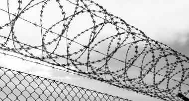 Metal bir çitin üzerinden dikenli teller - güvenlik veya münzevi konsepti