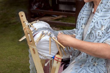 Traditional bobbin lace making, woman hands closeup